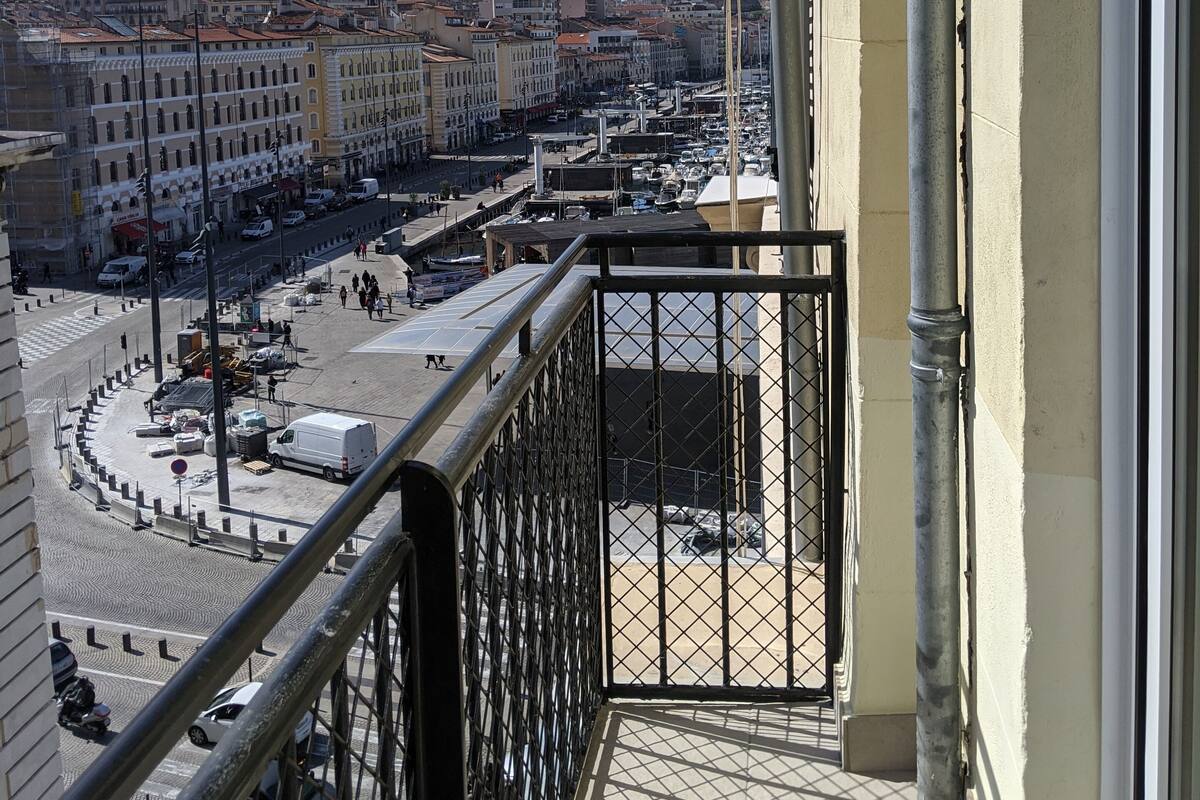 Ein Balkon mit Blick auf eine belebte Straße und Häuser.