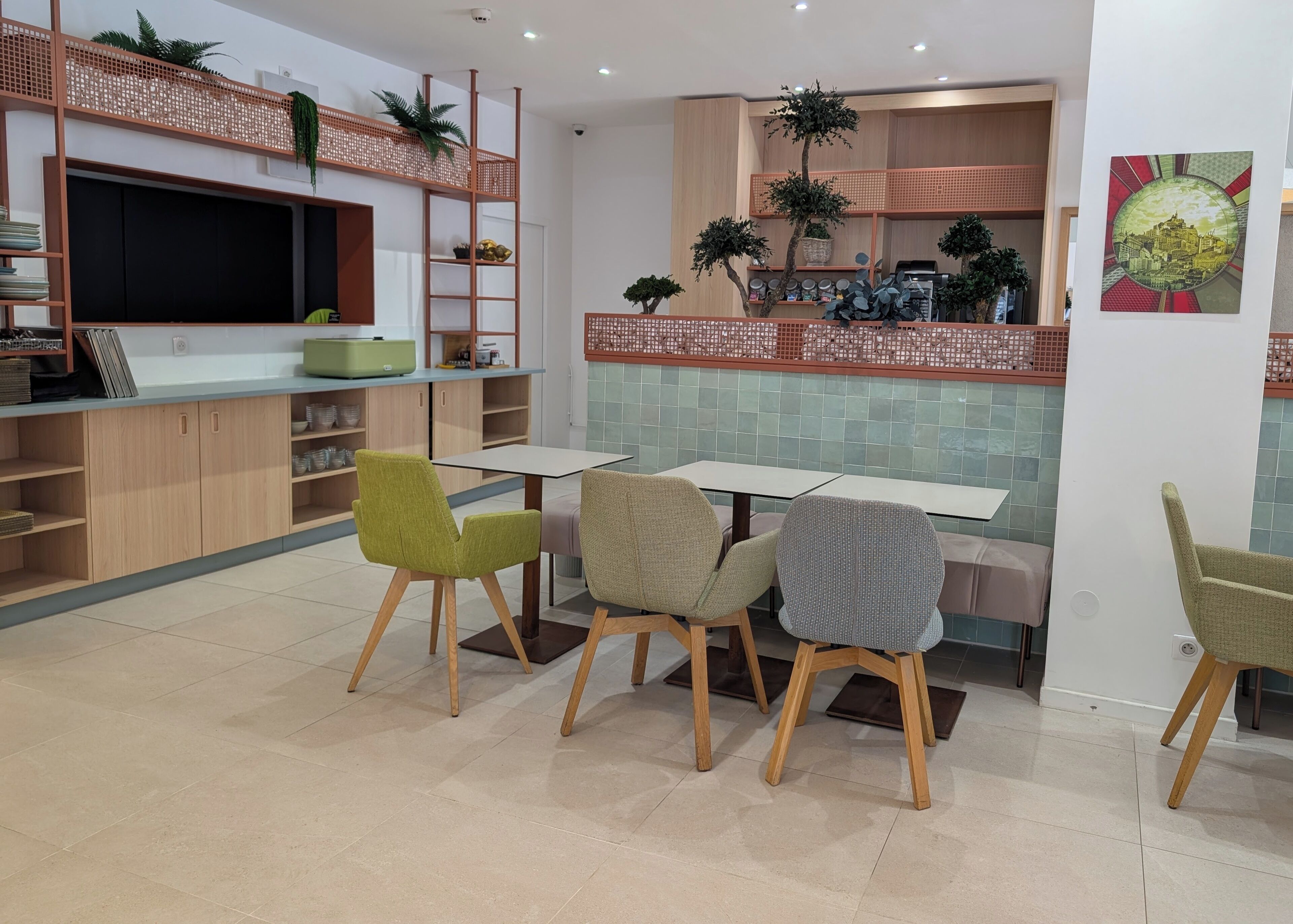A modern kitchen with a dining area, featuring a kitchen island, chairs, and a TV.