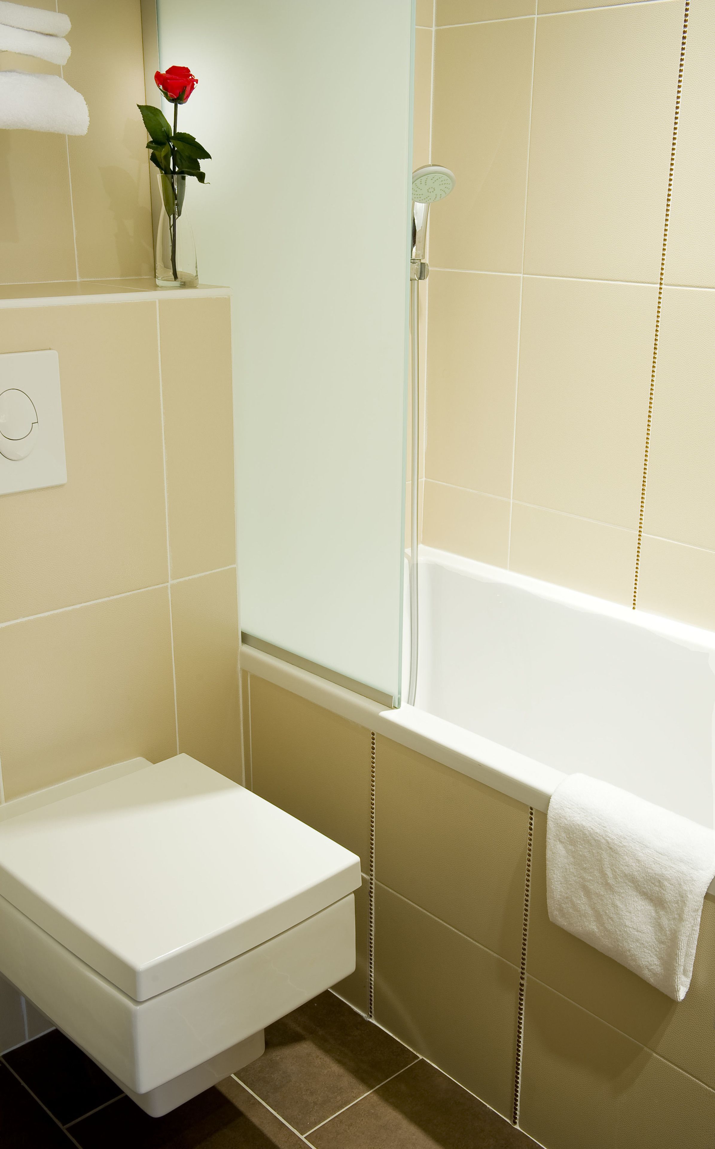 Un baño con inodoro blanco, cabina de ducha de vidrio y bañera.
