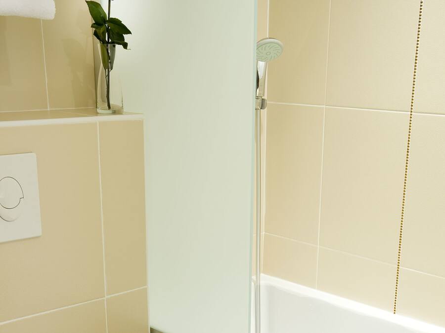 Un baño con inodoro blanco, cabina de ducha de vidrio y bañera.