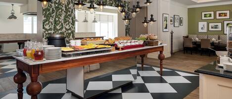 A breakfast buffet with a variety of food items and a checkered floor pattern.
