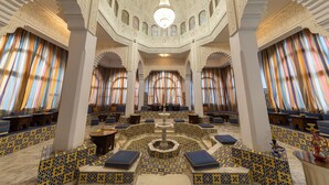 A spacious interior with patterned flooring, multiple seating areas, and a central fountain. - Marhaba Beach (Sousse)