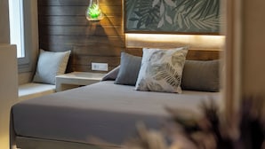 A bedroom with a bed, nightstands, a hanging plant, and a wall art piece.
