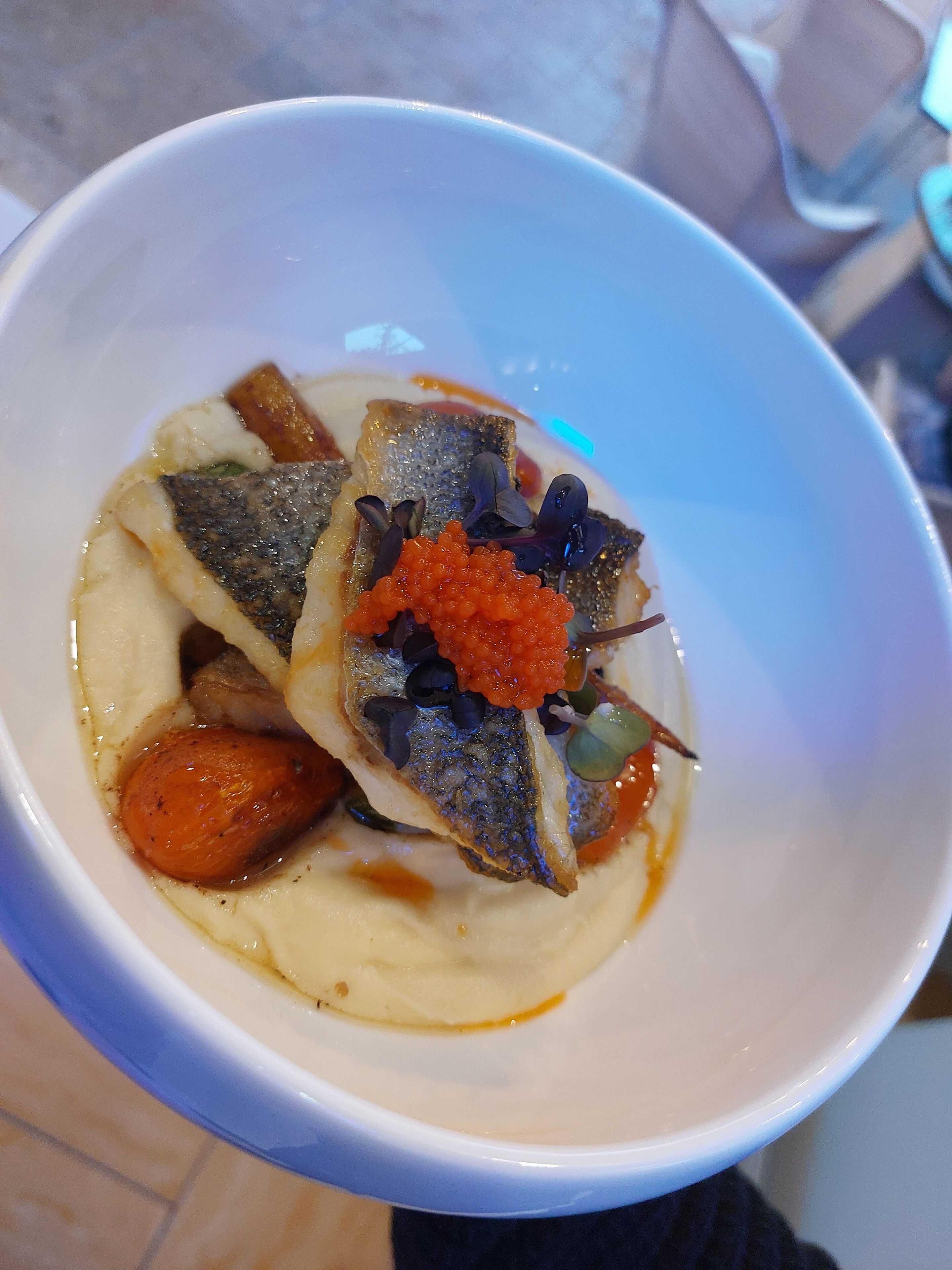 Eine Schüssel mit Fisch, Kaviar und Gemüse.