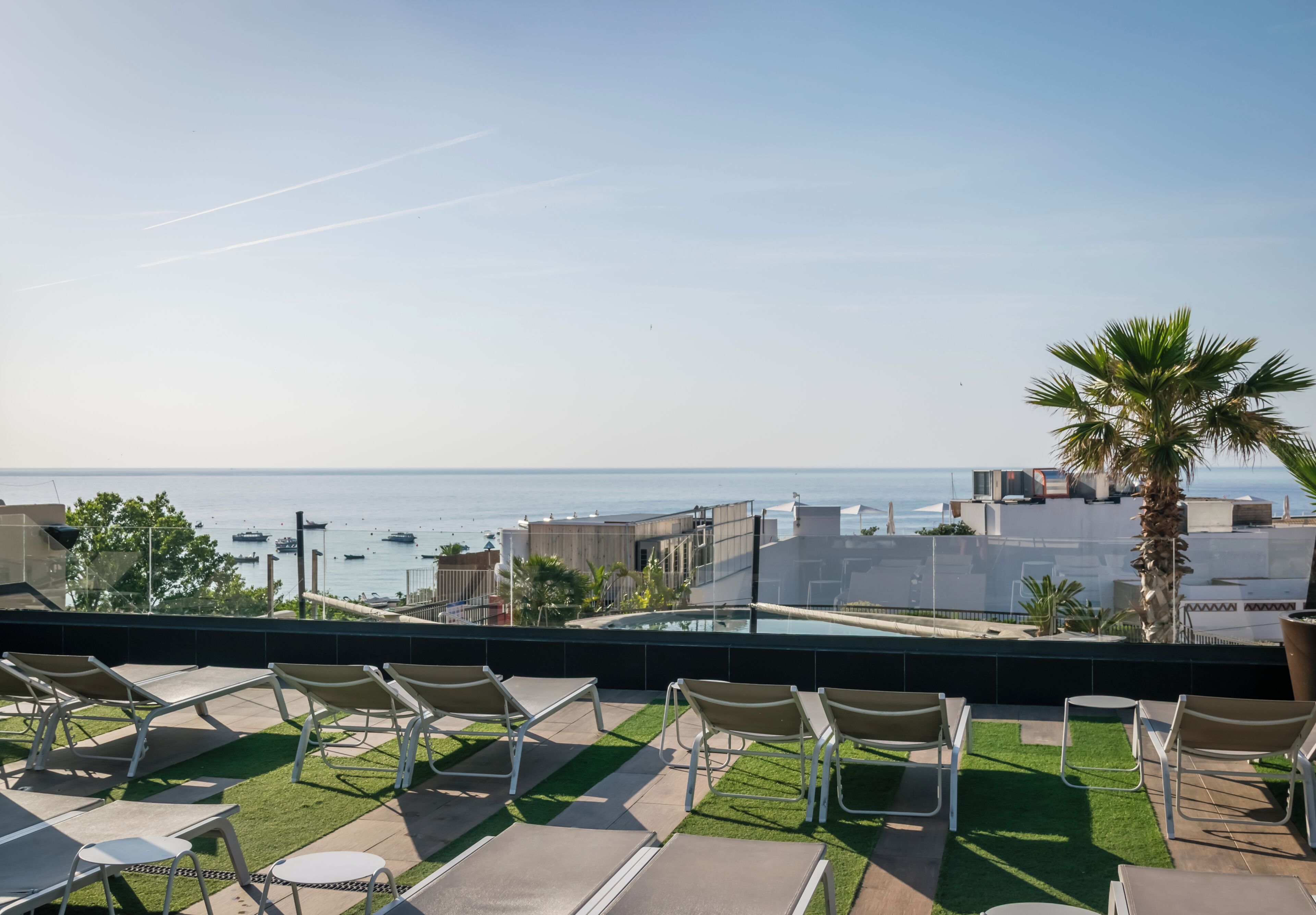 Terraza en la azotea con sillones de descanso y vistas al mar.