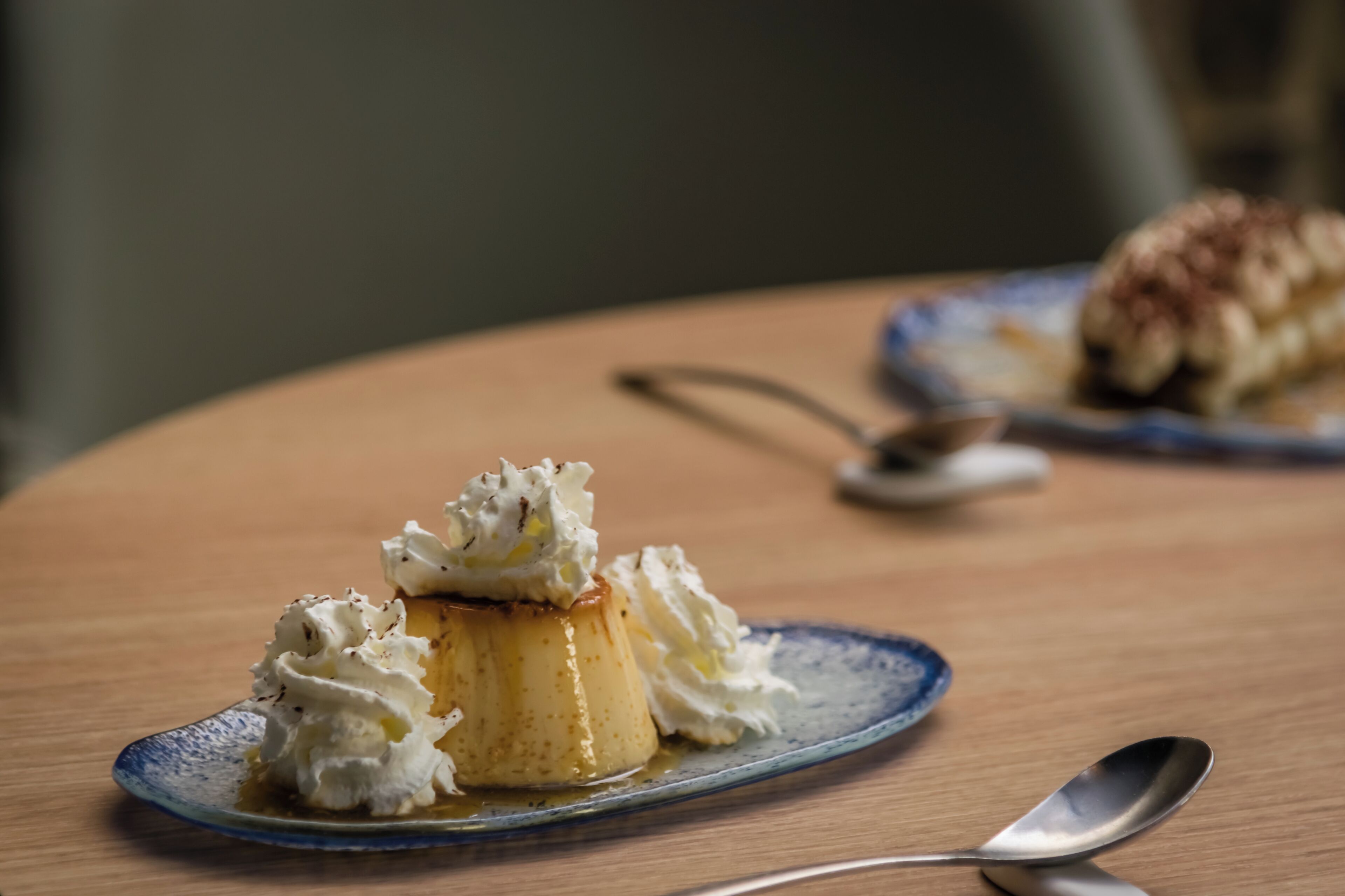 A dessert on a plate with whipped cream and a spoon.