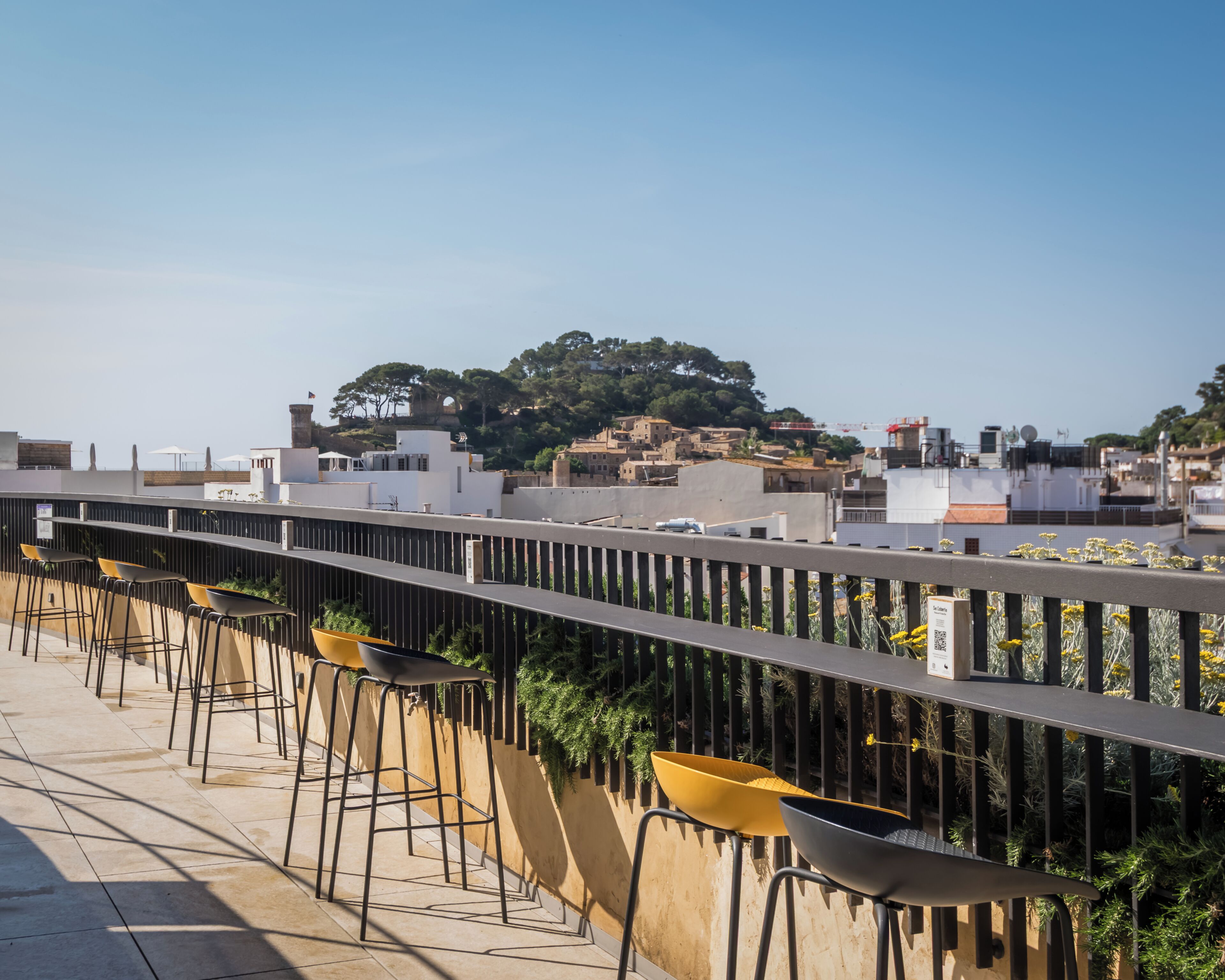 A rooftop terrace with outdoor seating and a view of the cityscape.