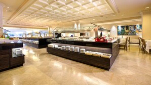 Un espace buffet doté de plusieurs points de service, d’une rambarde en verre et d’un plafond pourvu d’un éclairage encastré.