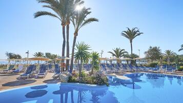 Una piscina cubierta, una piscina al aire libre, sombrillas, tumbonas