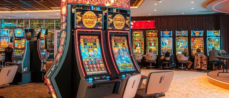 Zona de casino bien iluminada con varias máquinas tragamonedas, incluyendo una máquina Dragon Link destacada, y algunas sillas dispuestas al frente.