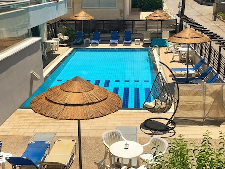 Außenpool, Sonnenschirme, Liegestühle. Caravel Apartment Hotel