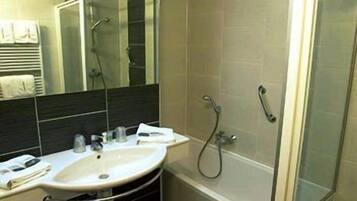 Ein modernes Badezimmer mit einer begehbaren Glasdusche, einem weißen Waschbecken und einem Spiegel.