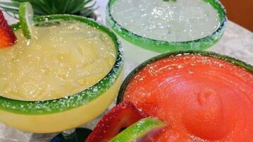 Drei Cocktails mit Limettenscheiben auf einem Tisch.