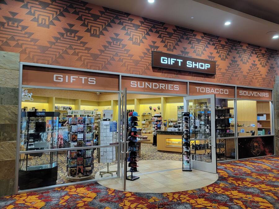 Tienda de regalos con secciones para obsequios, artículos varios, tabaco y recuerdos.