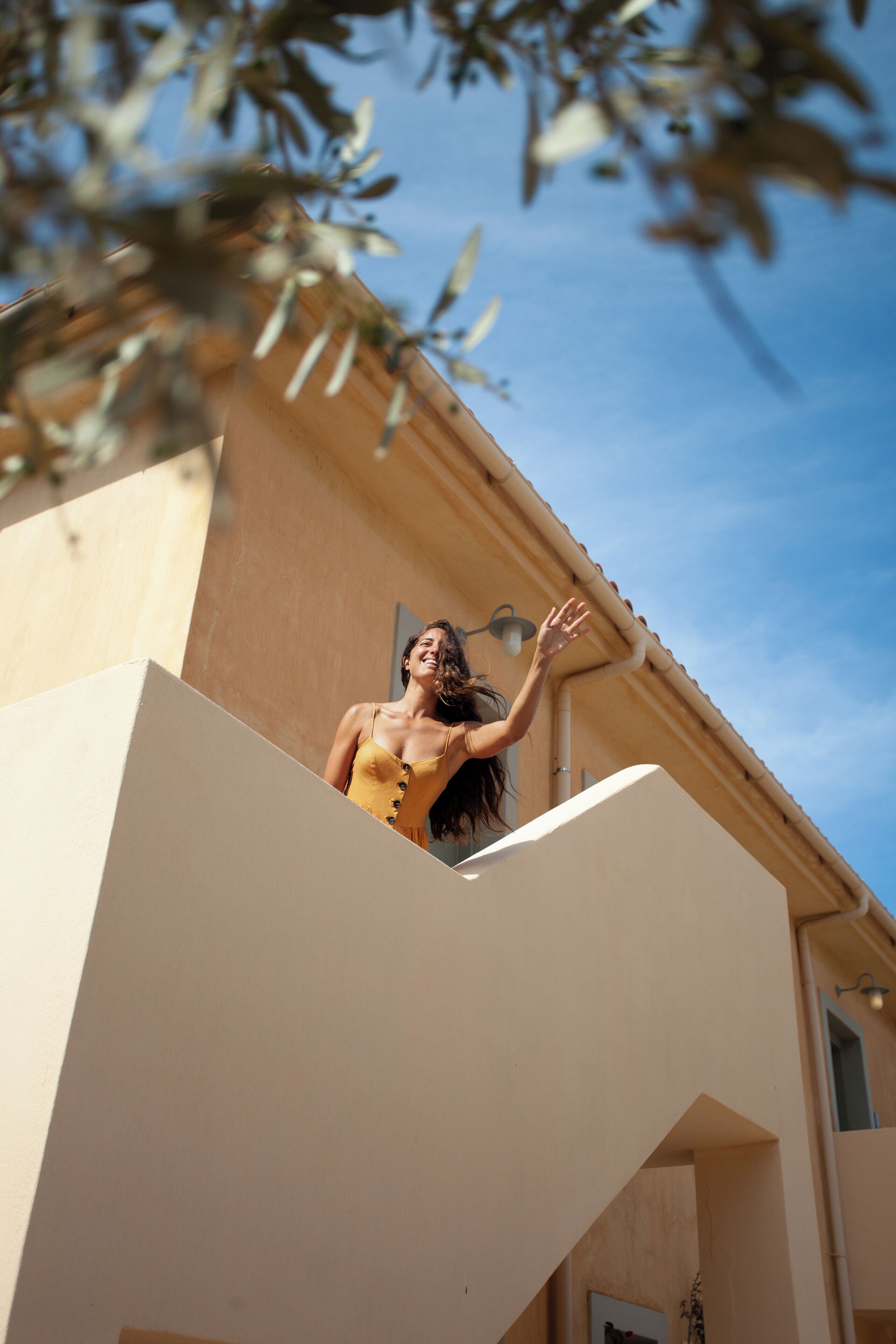 A person standing on a balcony with a clear view of the sky.
