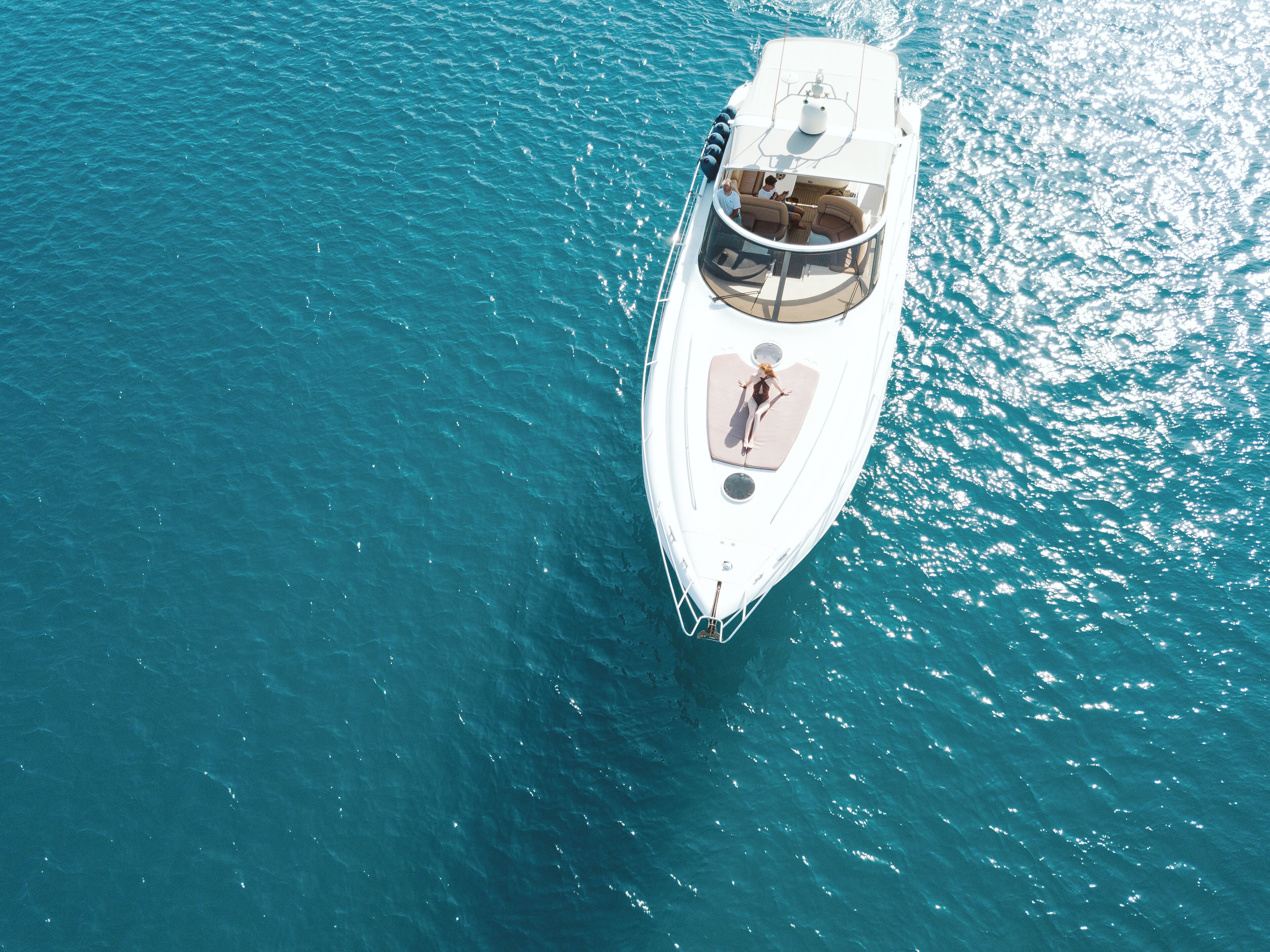 Ein Luftbild einer Yacht mit einem geräumigen Deck und einem überdachten Sitzbereich.