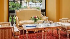 A room with a large window, a sofa, a coffee table, and a patterned carpet. - Palace Hotel (Como)