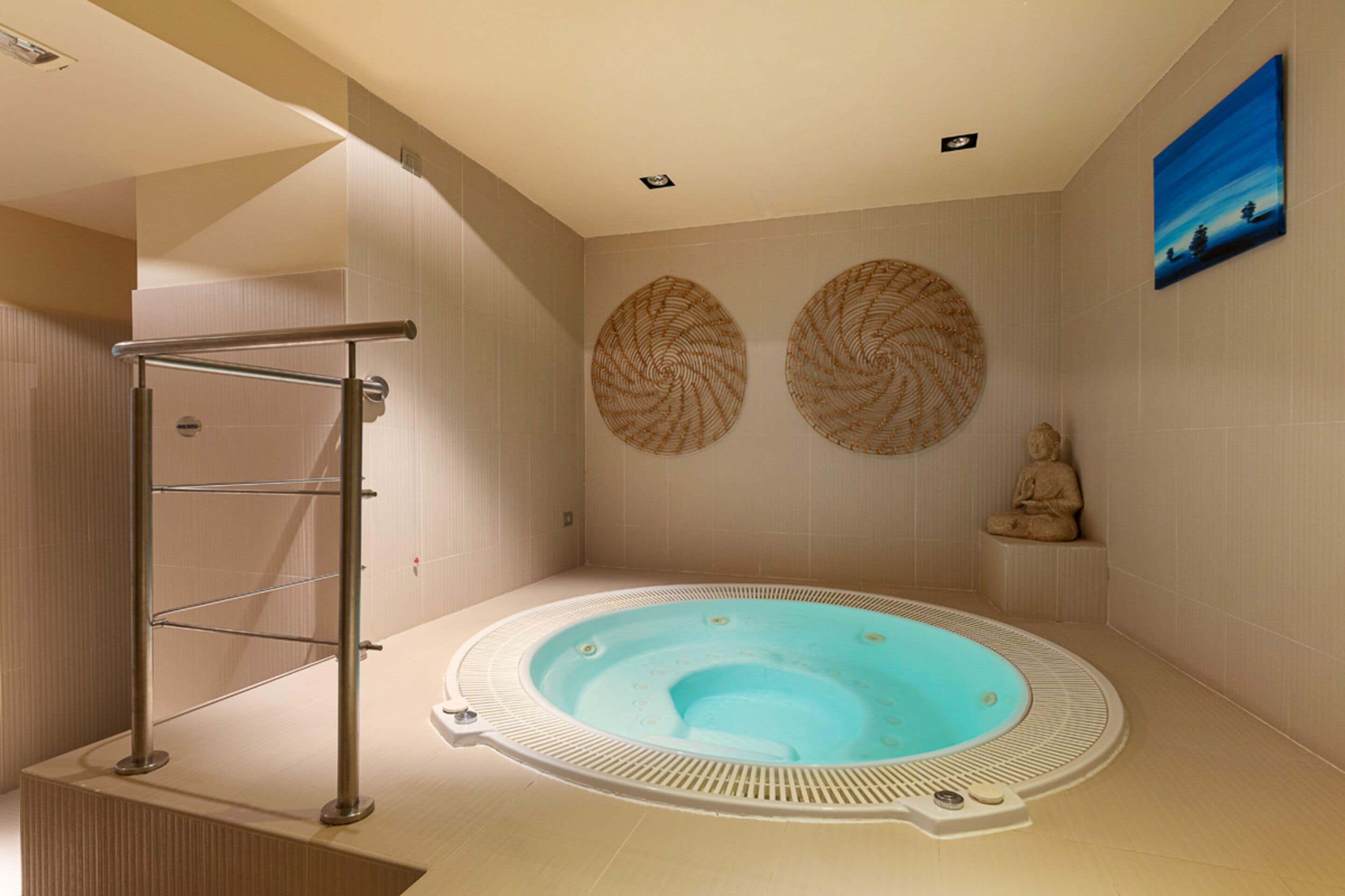 A modern bathroom with a freestanding bathtub, a towel rack, and decorative wall art.