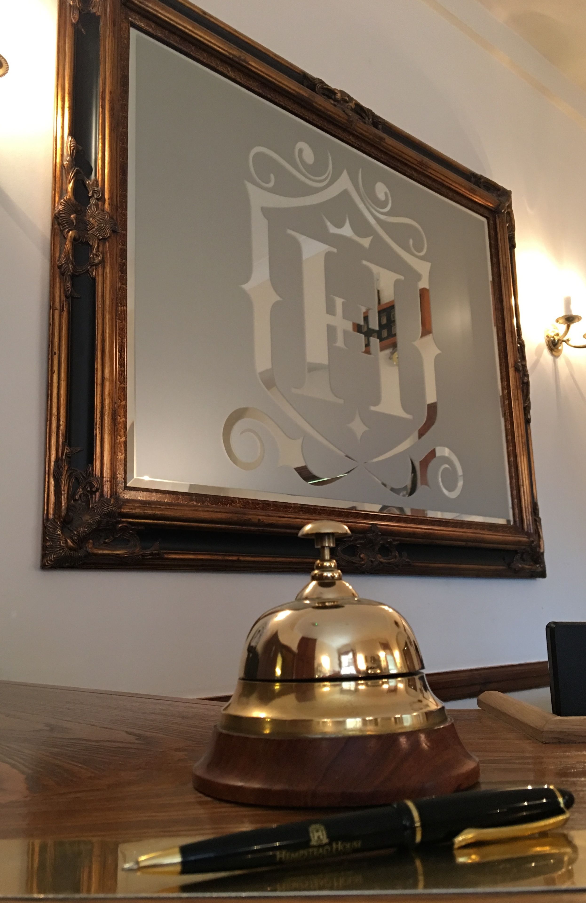 A framed emblem with a bell on a wooden surface.