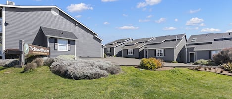 A residential building with a sign for "The Beach House Inn" and a well-maintained lawn.