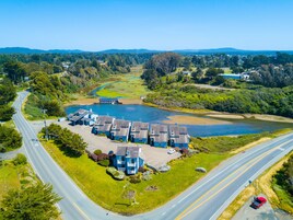 A residential area with a large body of water, a bridge, and a road.
