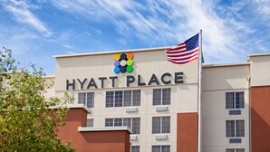 Rakennuksessa on kyltti, jossa lukee ”HYATT PLACE”, ja sen edessä liehuu Yhdysvaltain lippu.