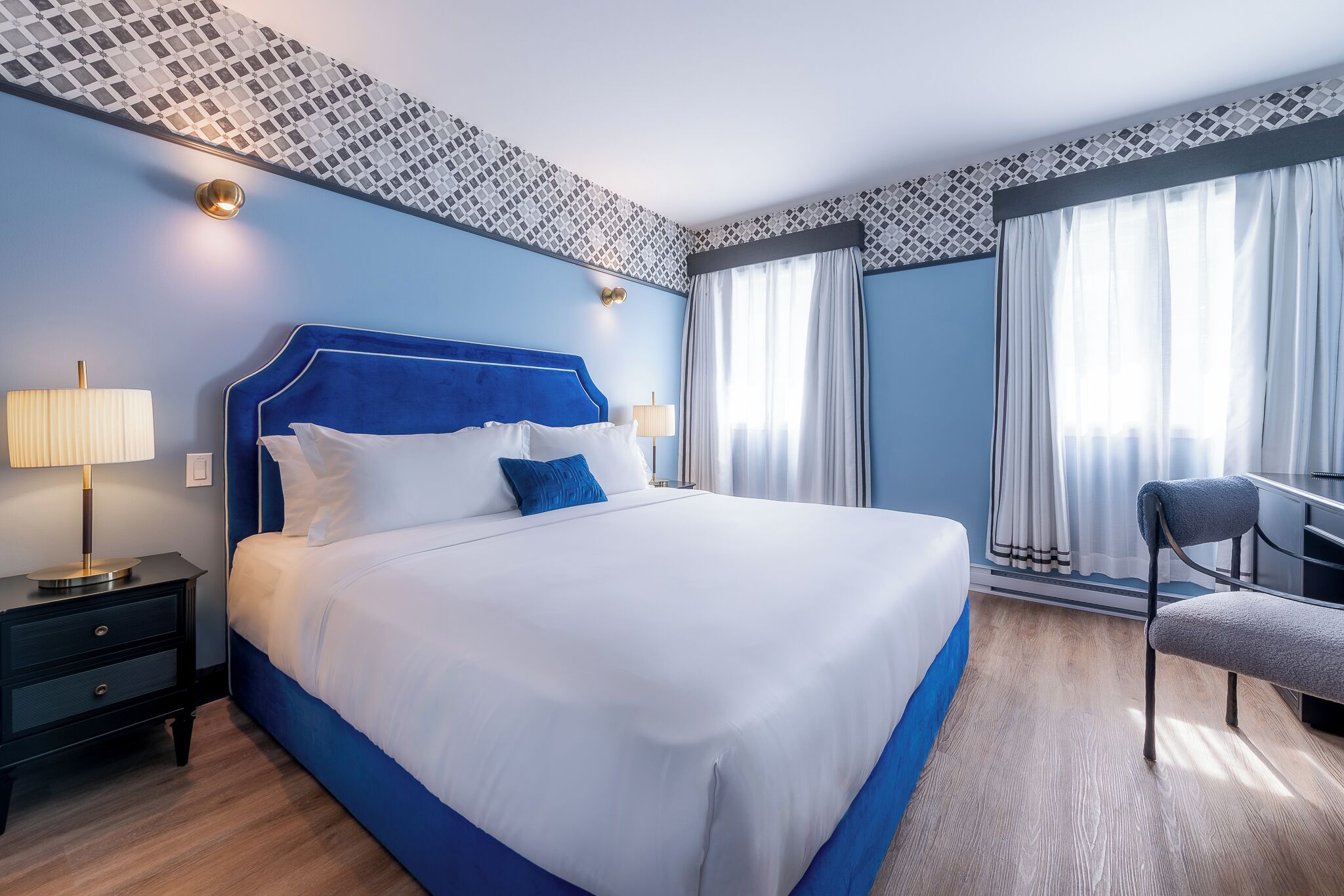 Une chambre d’hôtel avec un grand lit, un bureau et une chaise.