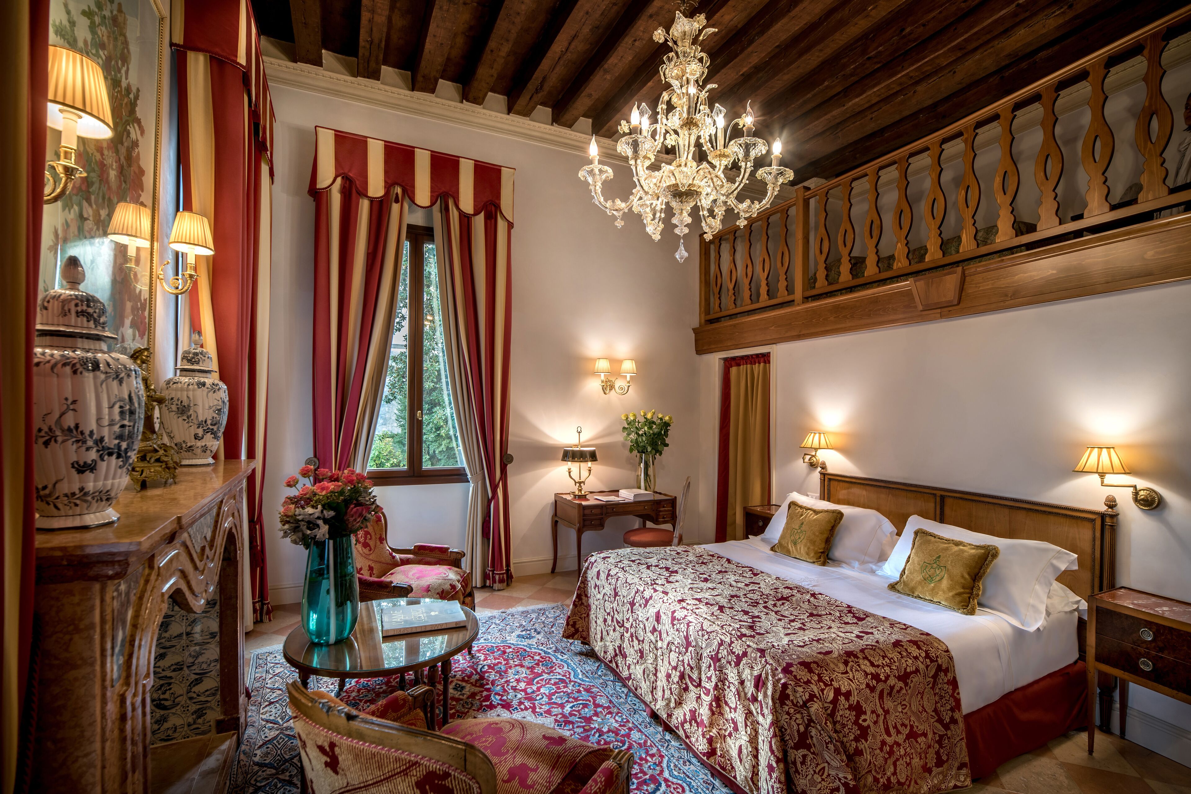 A well-appointed bedroom with a large bed, a chandelier, and a wooden ceiling.