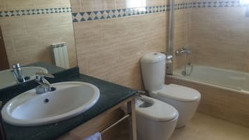 A bathroom with a sink, toilet, and shower.
