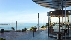 Una estructura con paredes de vidrio y techo curvo que da vistas a la costa.