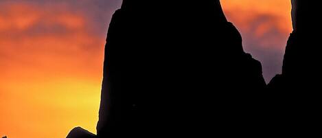 Silueta de una formación rocosa contra un cielo al atardecer.