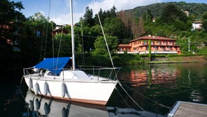 Un bateau était amarré à un quai, avec une maison en arrière-plan.