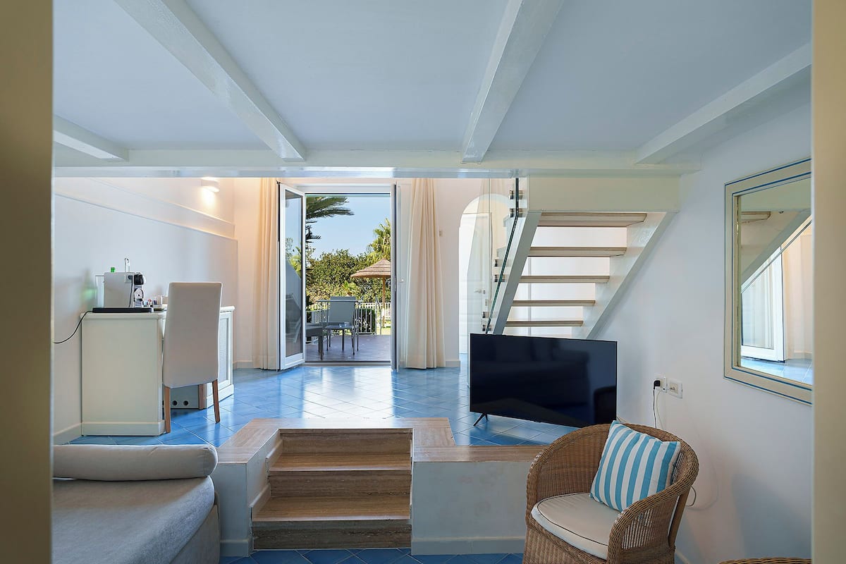 Suite – junior, hageutsikt | Safe på rommet, skrivebord, wi-fi (inkludert) og sengetøy