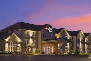 Un hotel Best Western Plus con fachada de piedra, varias entradas y zona de estar al aire libre.