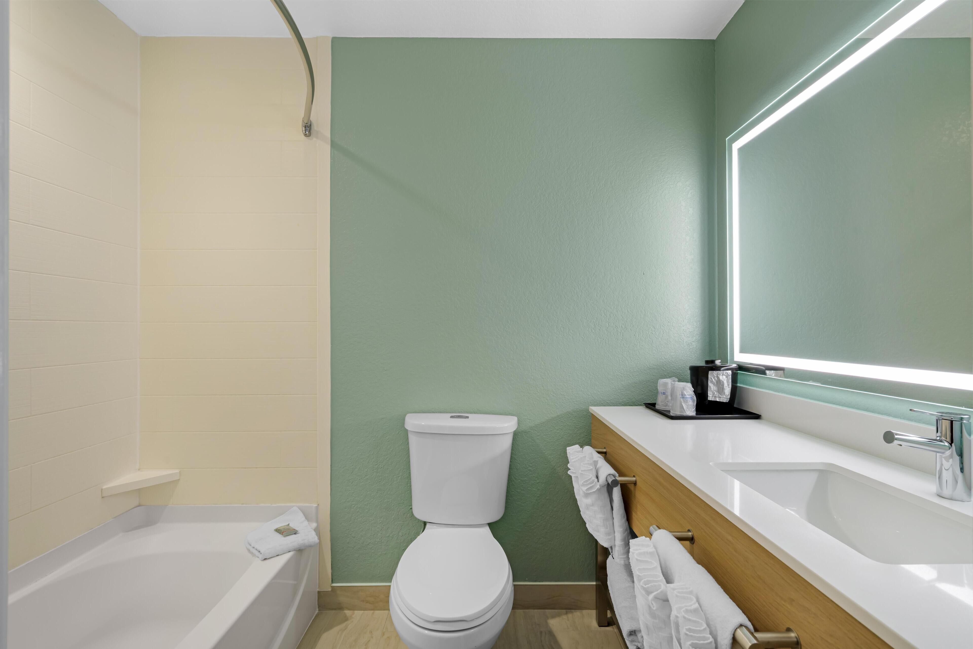 A modern bathroom with a bathtub, toilet, and sink.