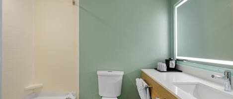 A modern bathroom with a bathtub, toilet, and sink.