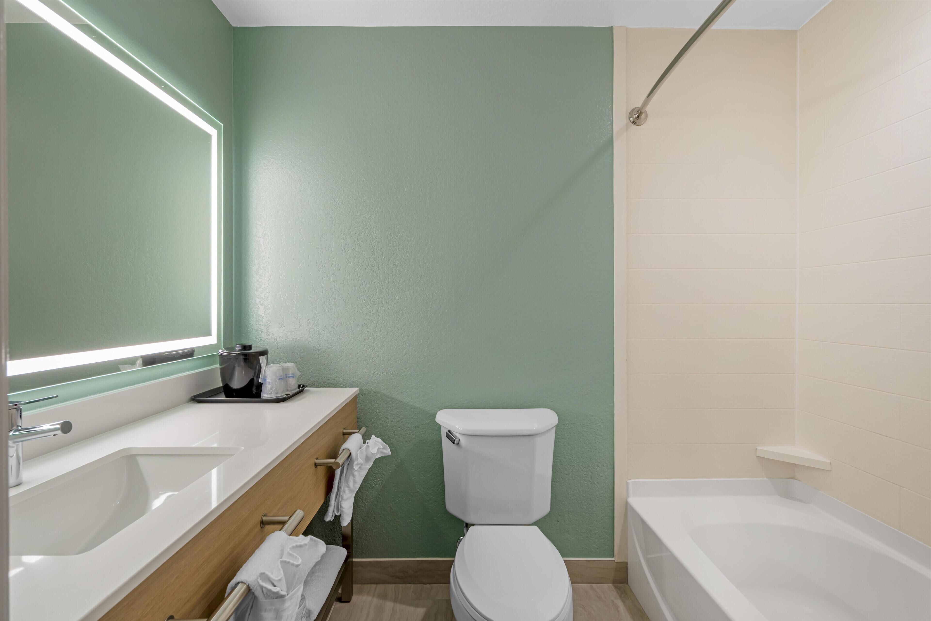 A bathroom with a white sink, a toilet, and a bathtub.