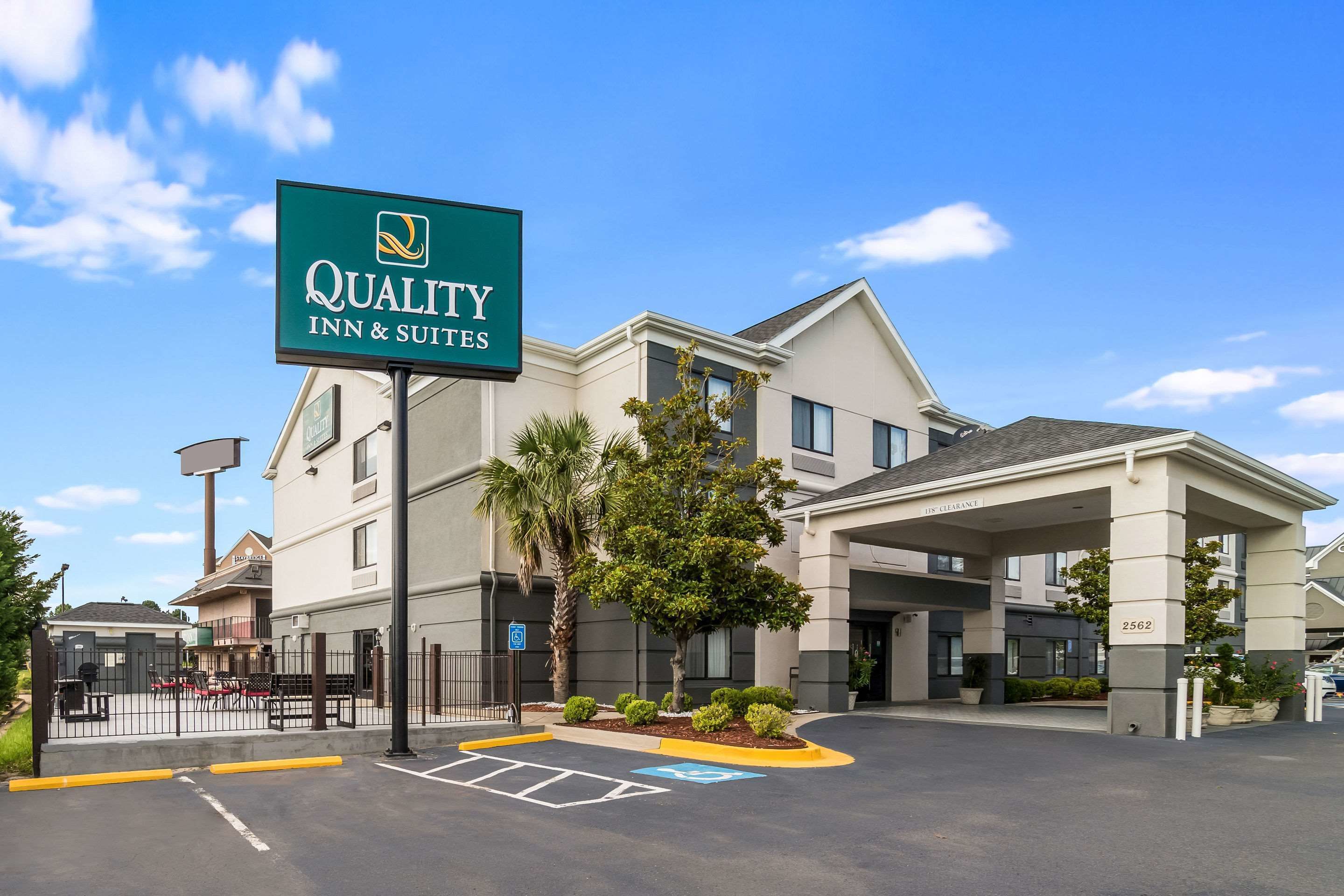 A Quality Inn & Suites building with a clear entrance, a parking area, and a signboard.