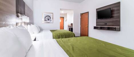 A hotel room with two beds, a TV mounted on the wall, and a painting on the wall.