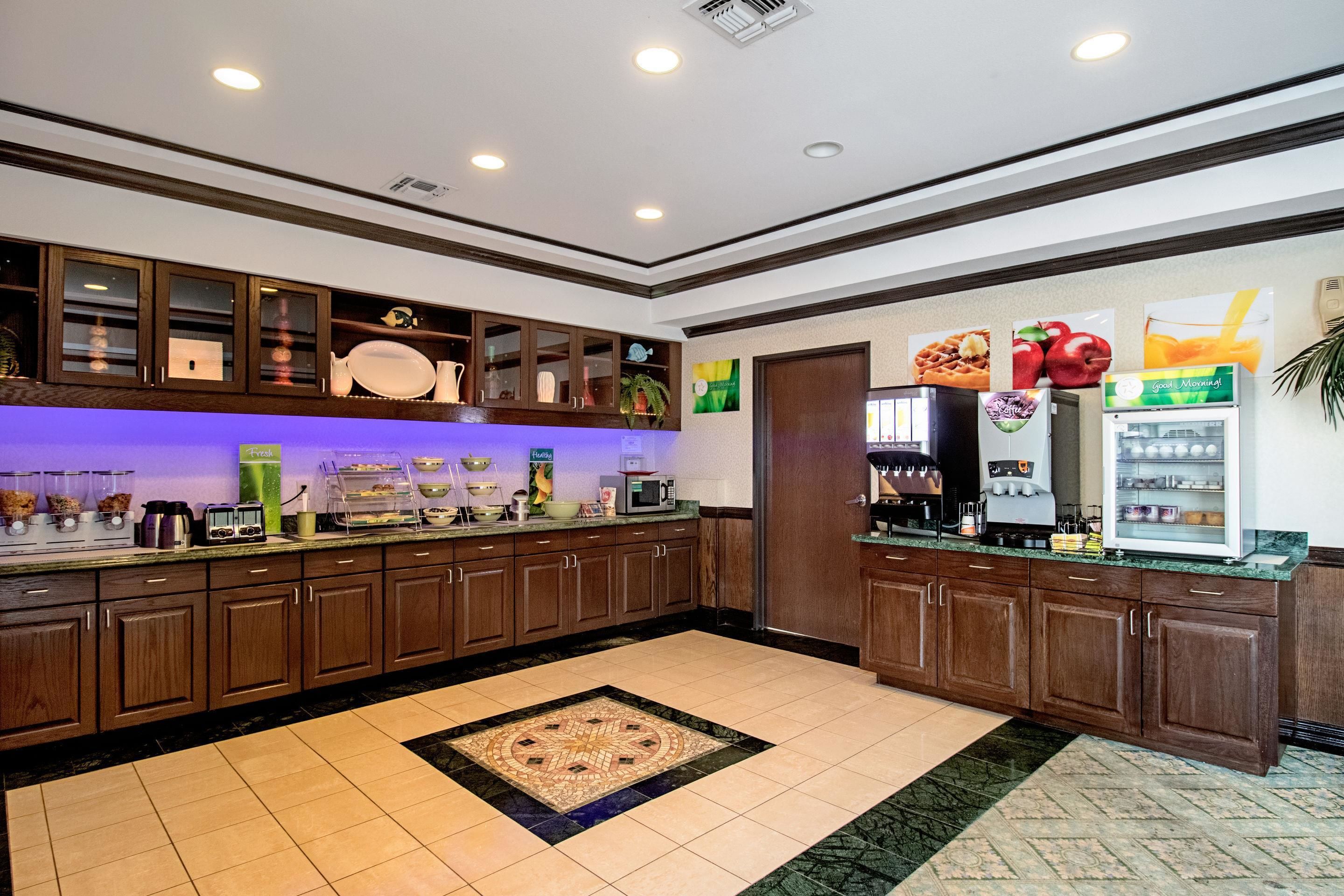 A modern kitchen with wooden cabinets, a marble countertop, and a central island.