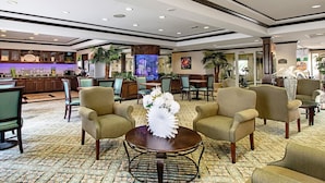 A spacious lobby with a reception desk, comfortable seating, and a decorative water feature.