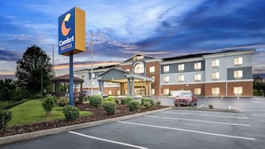 A Comfort Suites hotel with a modern design, a covered entrance, and a parking lot.