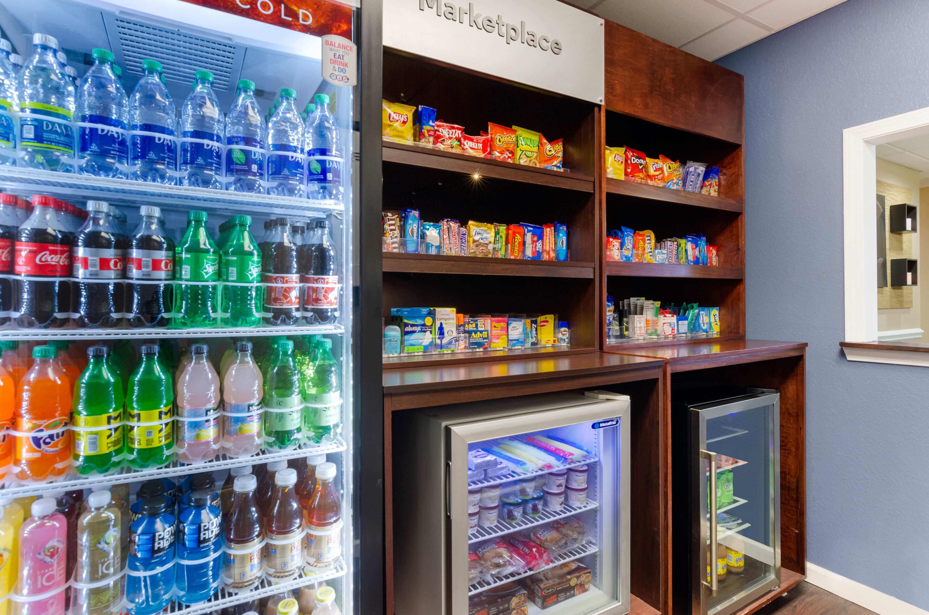 Uma área de máquinas de venda automática com diversas bebidas e lanches.