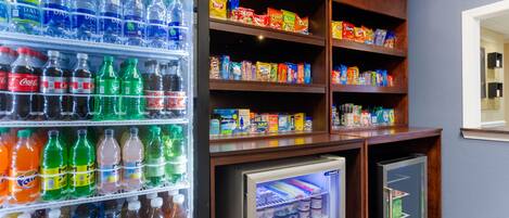 Uma área de máquinas de venda automática com diversas bebidas e lanches.