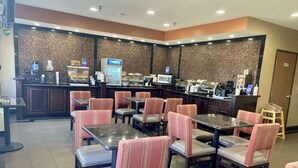 A restaurant with booths and tables, a counter with a coffee machine, and a brick wall. - Best Western Emporia Inn (Emporia)