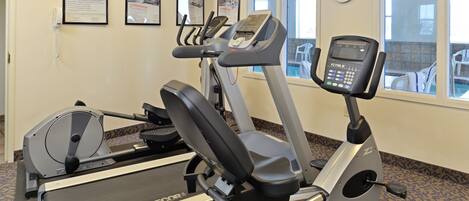 A fitness room with treadmills, elliptical machines, and a stationary bike.