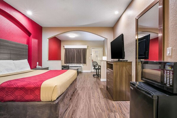 A hotel room with a bed, desk, chair, microwave, and TV. - Econo Lodge Inn & Suites Horn Lake - Southhaven (Horn Lake)