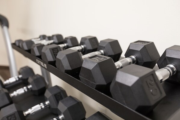 A rack of black dumbbells with weight markings.