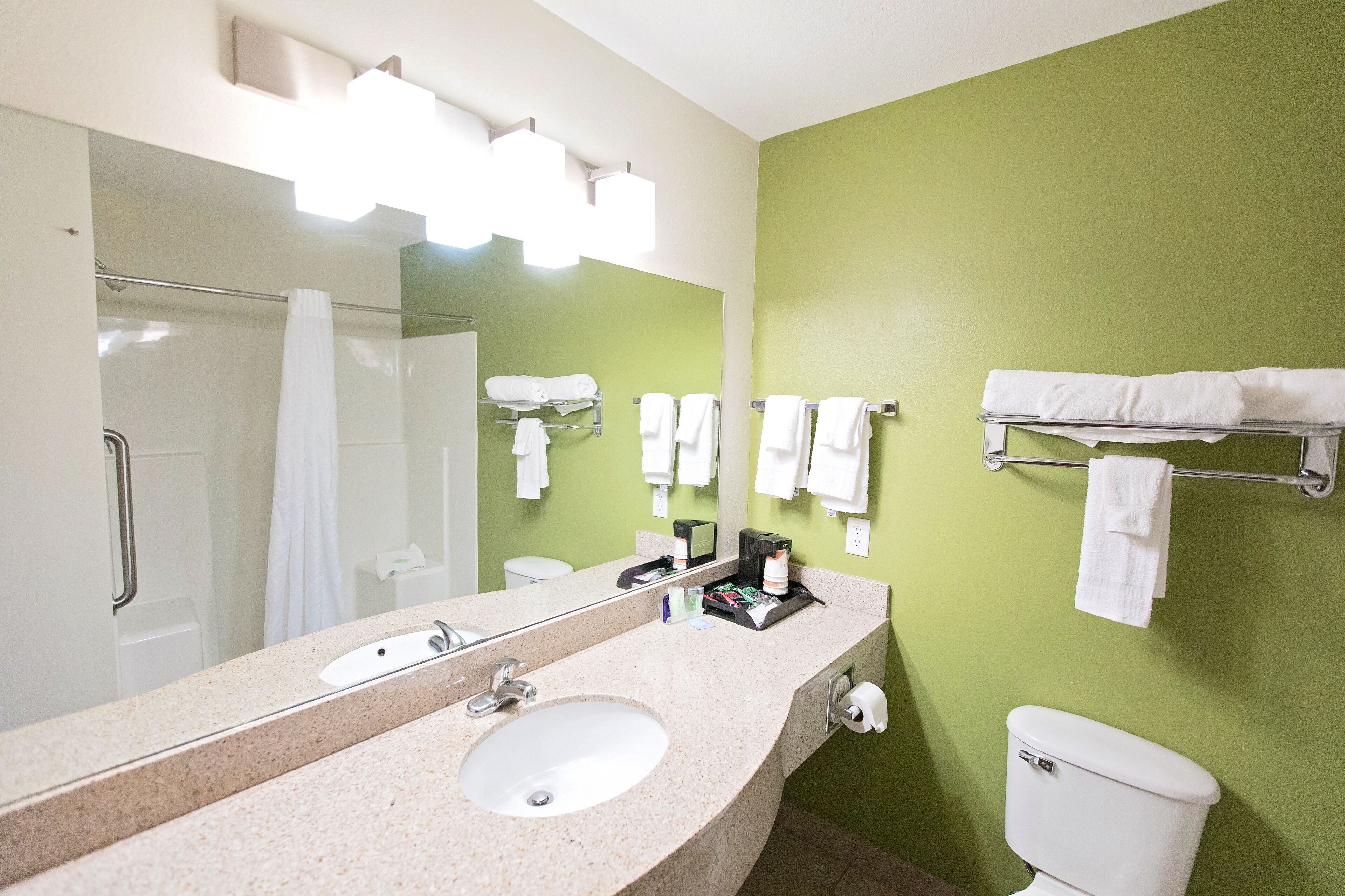 A bathroom with a sink, mirror, towel rack, and toilet.