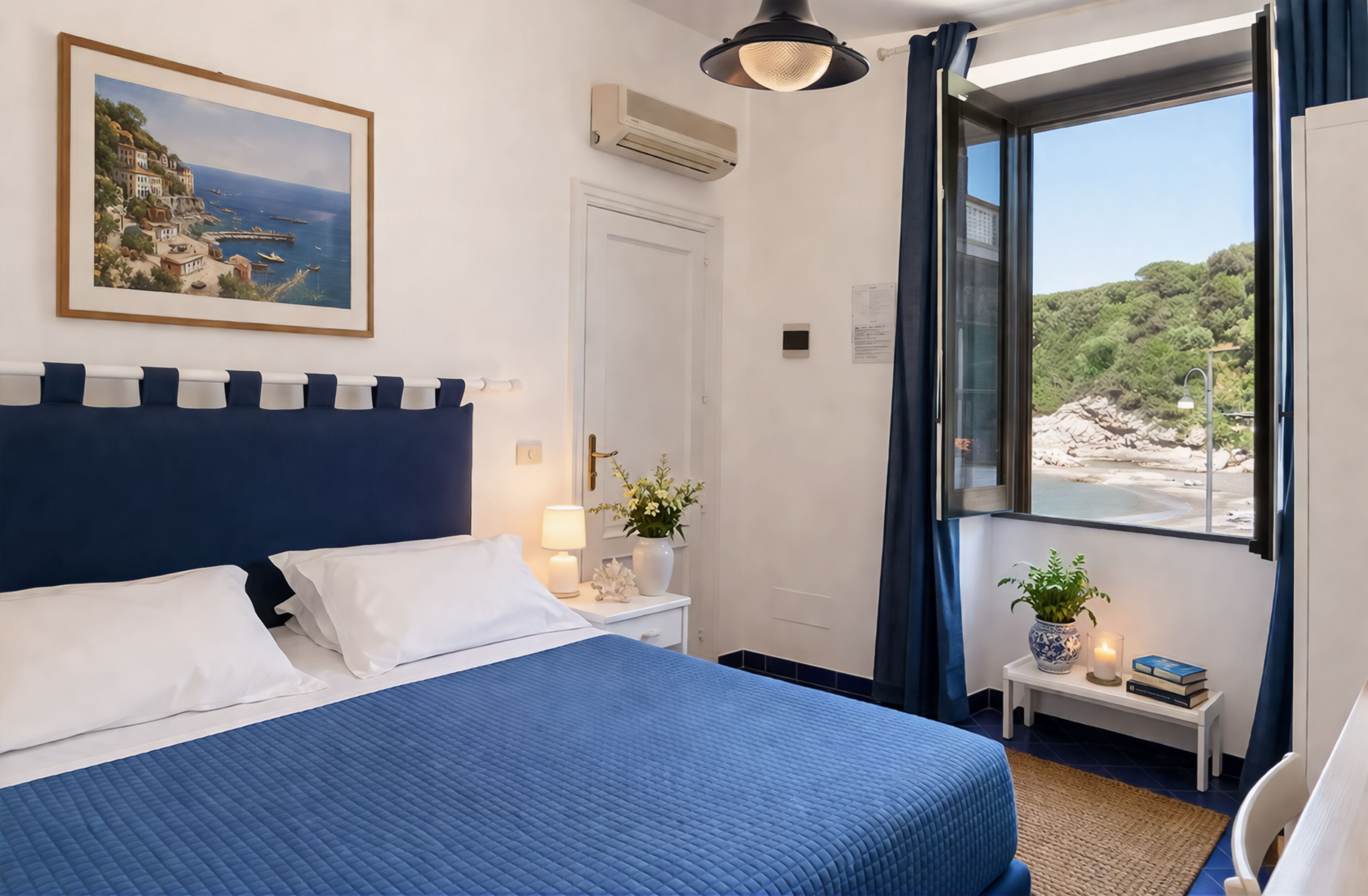 A bedroom with a bed, bedside table, lamp, and a window with a view of a coastal landscape.